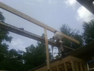 Carpenter setting a ridge beam over a new addition frame — Ice Dam Removal by Roofing Brothers in Murray City