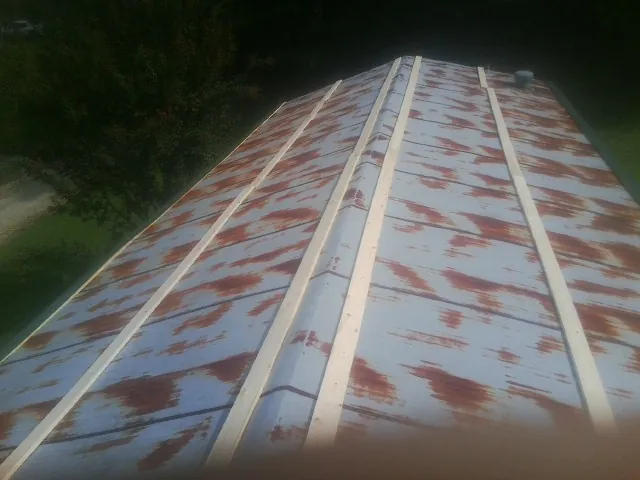 Rusted metal roof panels with new wood purlins before replacement — Storm Damage Roof Repair in Murray City by Roofing Brothers