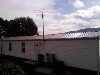 New metal roof on a single wide mobile home with a TV antenna in Murray City
