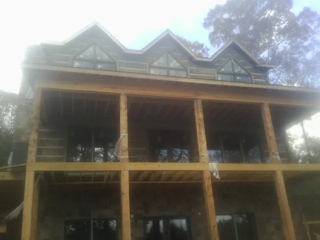 Dormers and porch framing on a large log home under construction — Roof Coating work by our crew in Murray City