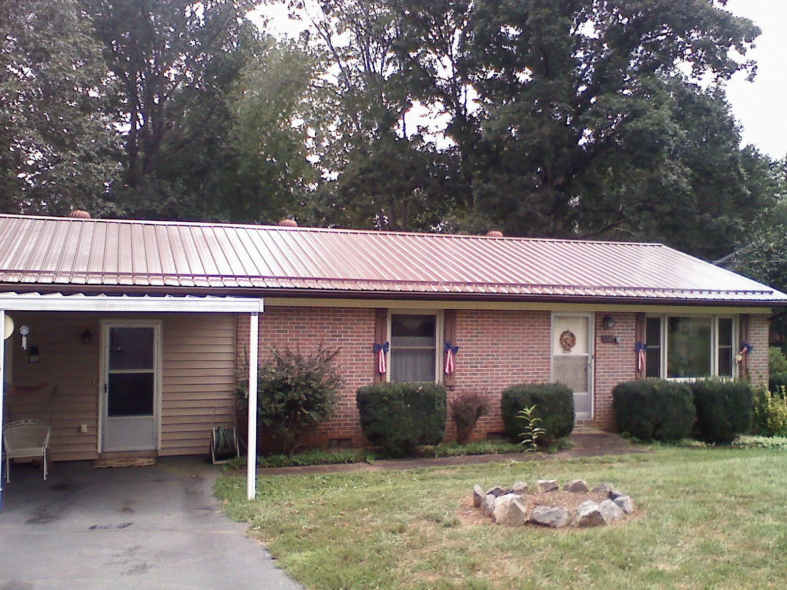 Bronze metal roof and carport on a brick ranch home — Roof Repair work by our crew in Murray City
